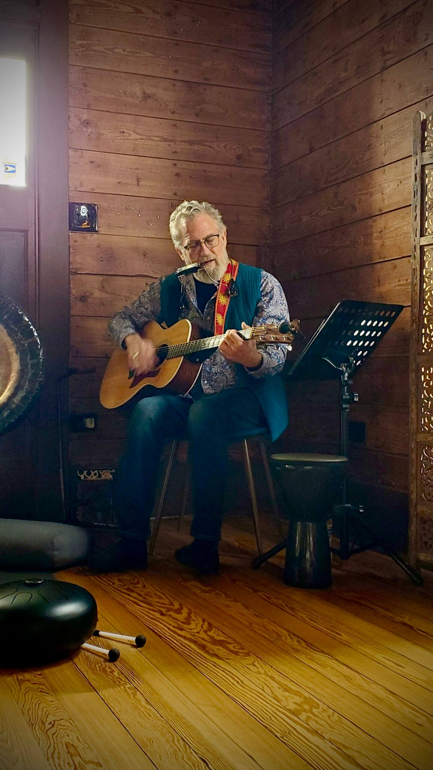 Ray Songs playing guitar and harmonica at Unbound Collective in San Antonio, Texas